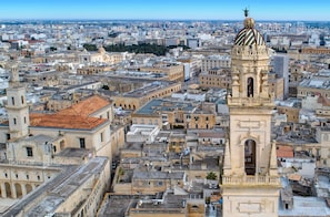 A cityscape with a prominent tower featuring a dome and a bell tower.