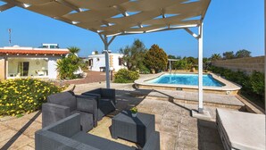 An outdoor patio with a pool, seating area, and a pergola structure. - 2210 Villa Sergi by Perle di Puglia (Gagliano del Capo)