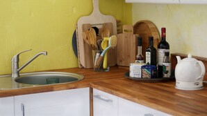A kitchen with a wooden countertop, a sink, and various kitchen utensils and appliances. - Souterrainwohnung mit Großem Garten (Kassel)