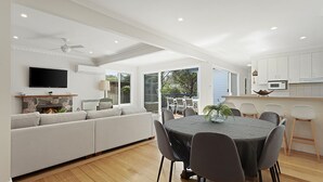 Una cocina moderna con comedor, chimenea y televisor montado encima.