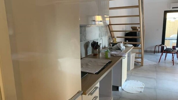 Una cocina con encimera de madera, un lavabo y una escalera.