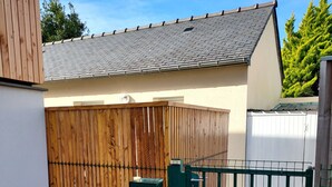 Ein eingezäuntes Gelände mit Holzpfeilung und grünem Metalltor.