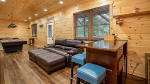 A cozy room with a pool table, leather sofa, and a bar area. - Spacious Log Home with EV Charger (Vilas)
