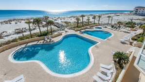 Ein Resort mit zwei Schwimmbecken, Meerblick und Liegebereichen.