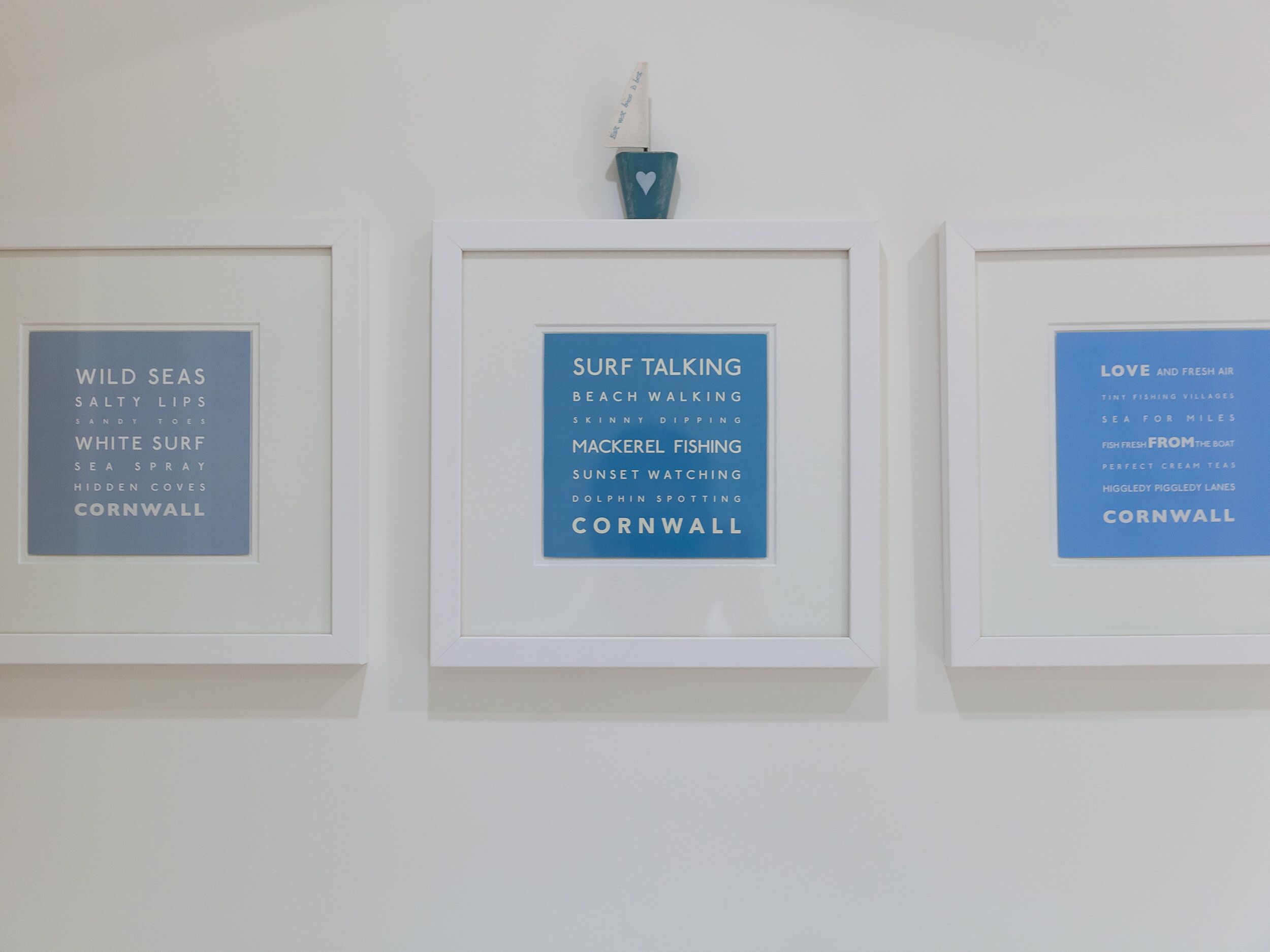 Drie borden met tekst, elk bevestigd aan een witte muur.