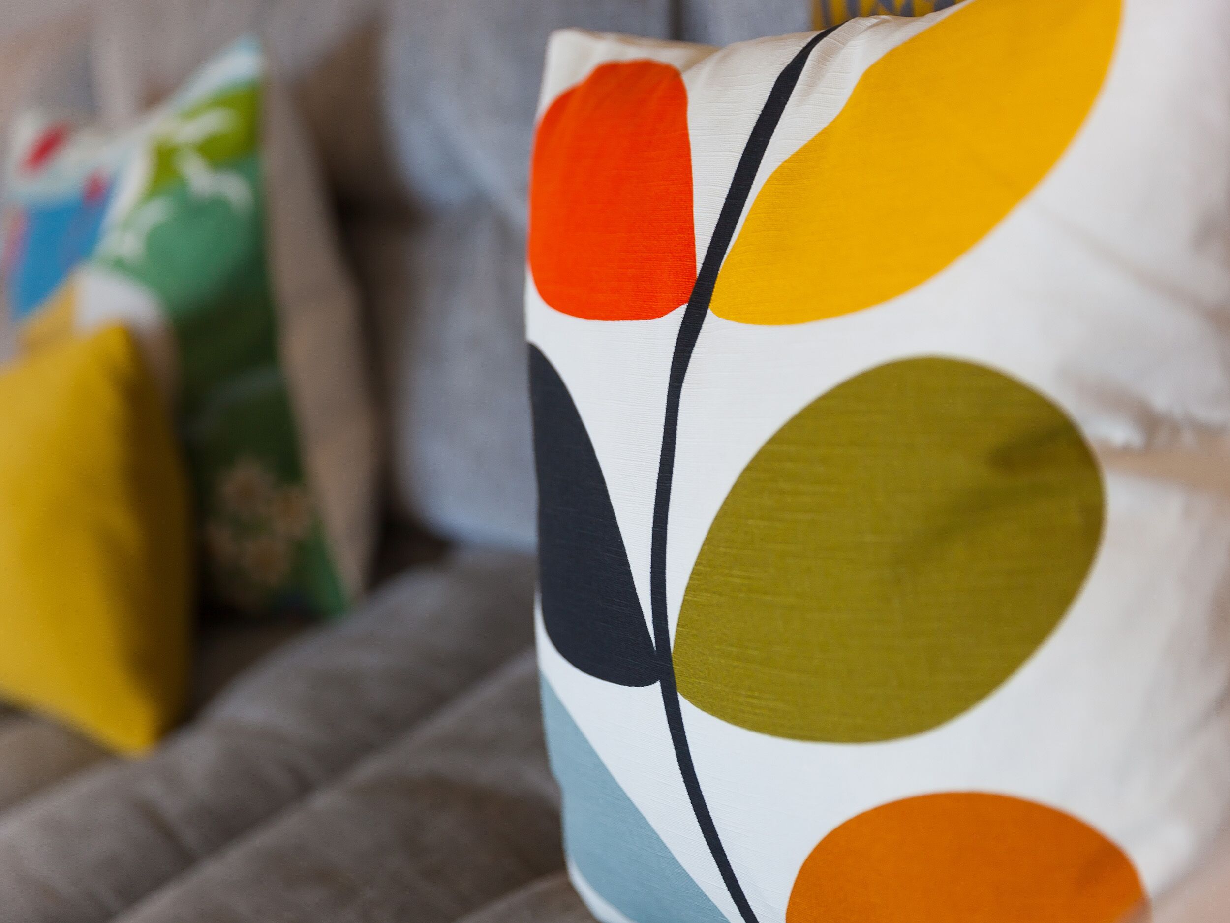 A close-up of a colorful pillow with abstract shapes.