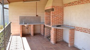 Eine Außenküche mit einem Backofen aus Ziegeln und einer Arbeitsplatte aus Granit.