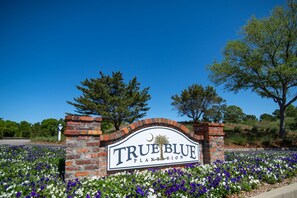 A sign for True Blue Plantation with a brick archway and a flower bed in front. - TB 66A Three Bedroom/Two Bath unit in True Blue (Pawleys island)