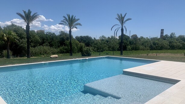 A rectangular swimming pool with clear blue water, surrounded by a tiled deck. - Bio Resort Mediterraneo (Sant Martí Sarroca)