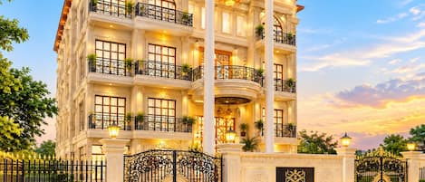Un hotel de varios pisos con balcones, una entrada imponente y una fachada bien iluminada.
