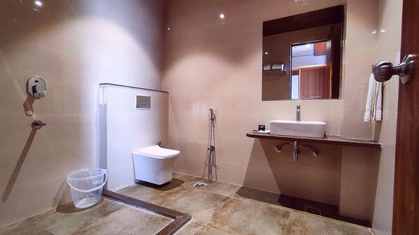 Un baño moderno con inodoro, lavamanos y ducha.