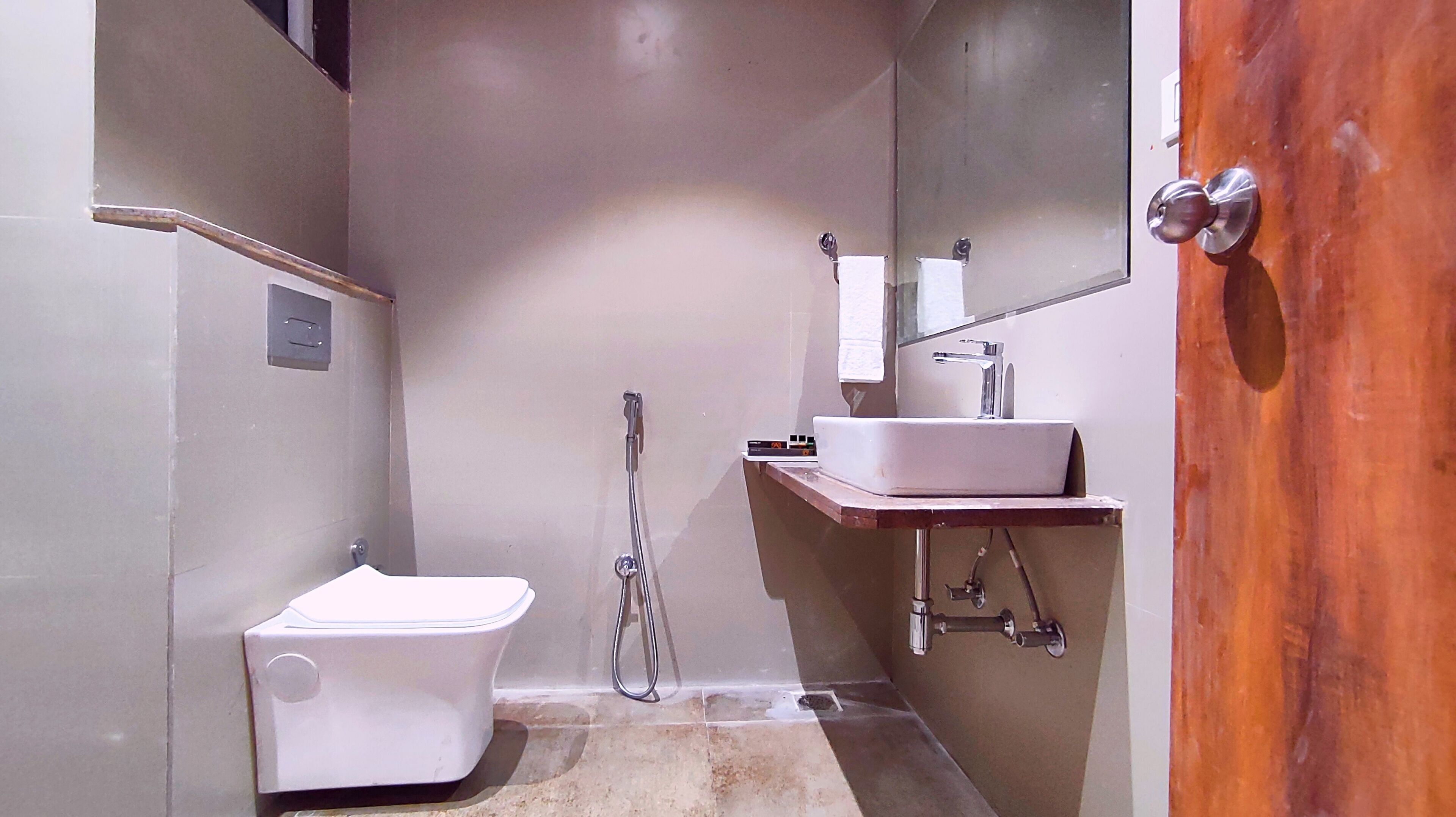 Un baño pequeño y funcional con inodoro blanco, lavamanos y ducha.