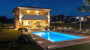 A two-story house with a swimming pool, outdoor seating, and a well-lit patio area. - Modern Villa Amoroso in western Istria (Nova Vas)