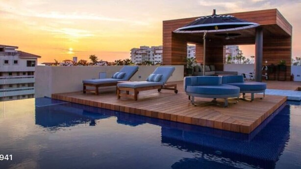 A rooftop pool area with lounge chairs and a wooden deck. - Casa Paraiso - Luxury 2 Bed 3 Bath at Pavilion Lux (Puerto Vallarta)