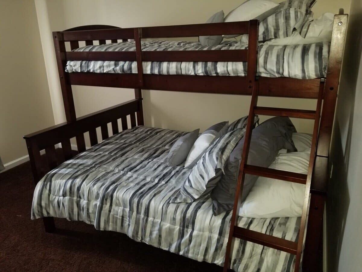 A bunk bed with a striped bedspread and pillows.