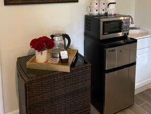 Prepare meals in this functional kitchen with a refrigerator, microwave, and sink.