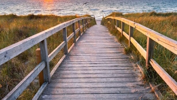 A wooden boardwalk leading to the ocean with a sunset in the background. - Paris Suite @Carolina Beach, Walk to Carolina Beach State Park (Carolina Beach)