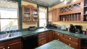 A kitchen with wooden cabinets, a dishwasher, a microwave, and a coffee maker. - Slatyfork Homestead - Cozy Farmhouse Near Snowshoe (Pocahontas County)