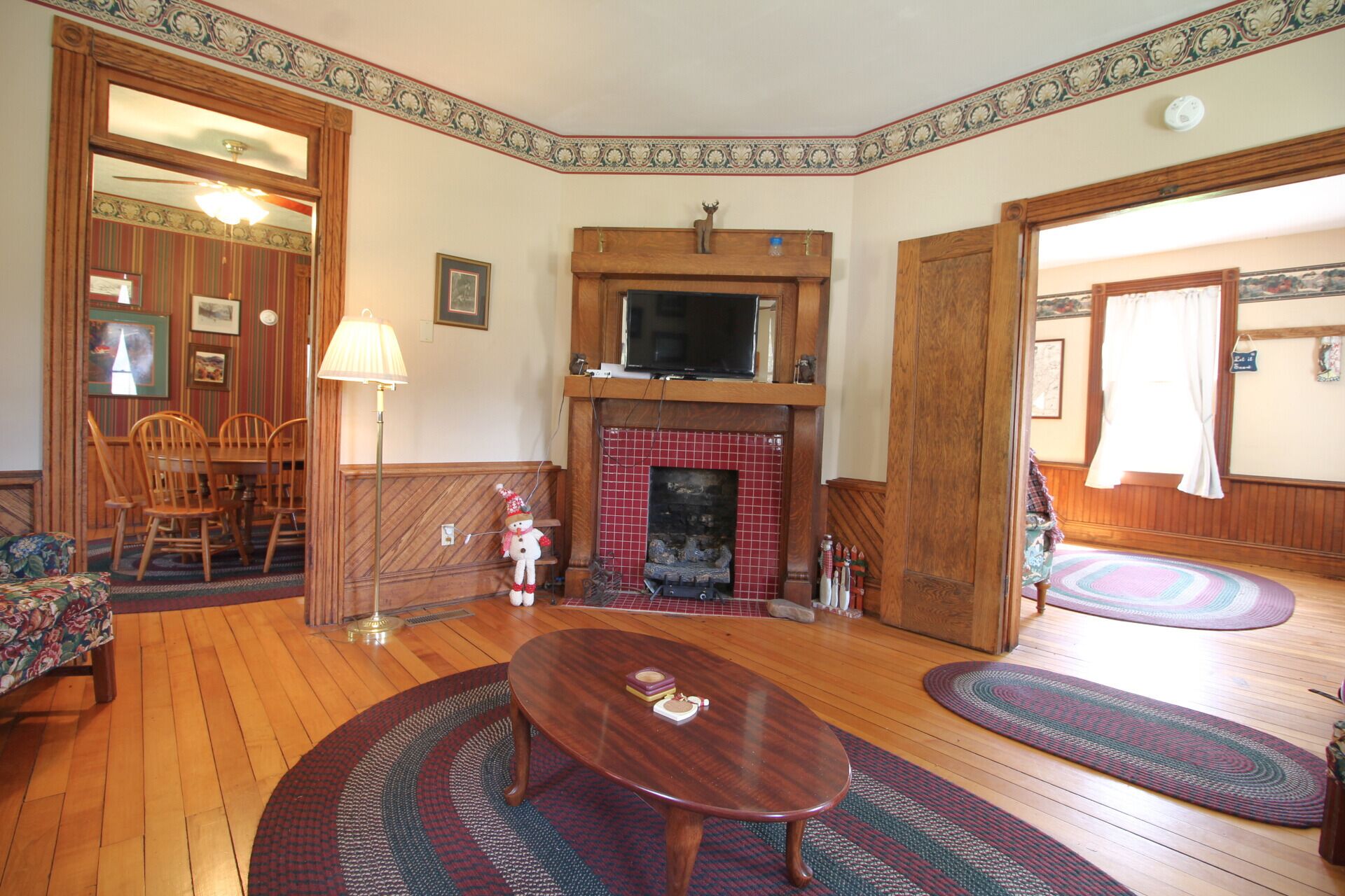 A living room with a fireplace, wooden furniture, and a television.