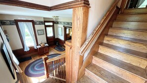 A wooden staircase with a view of a living room area. - Slatyfork Homestead - Cozy Farmhouse Near Snowshoe (Pocahontas County)