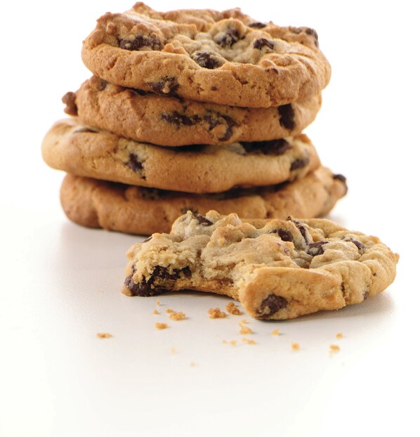 A stack of chocolate chip cookies with one cookie broken in half. - DoubleTree by Hilton Auckland Karaka (Karaka)