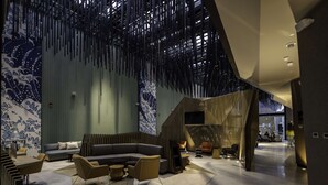 Un interior moderno con un sofá modular, un comedor y una escalera que sube a otro nivel.