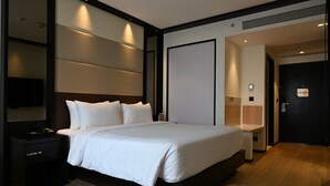 A modern hotel room with a large bed, bedside tables, a desk, and a flat-screen TV. - Hilton Garden Inn Pune Hinjawadi (Paud)
