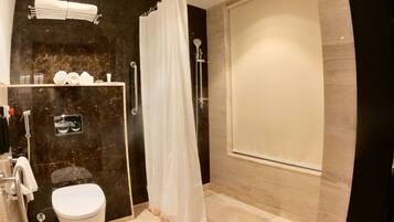 A modern bathroom with a toilet, shower, and vanity.
