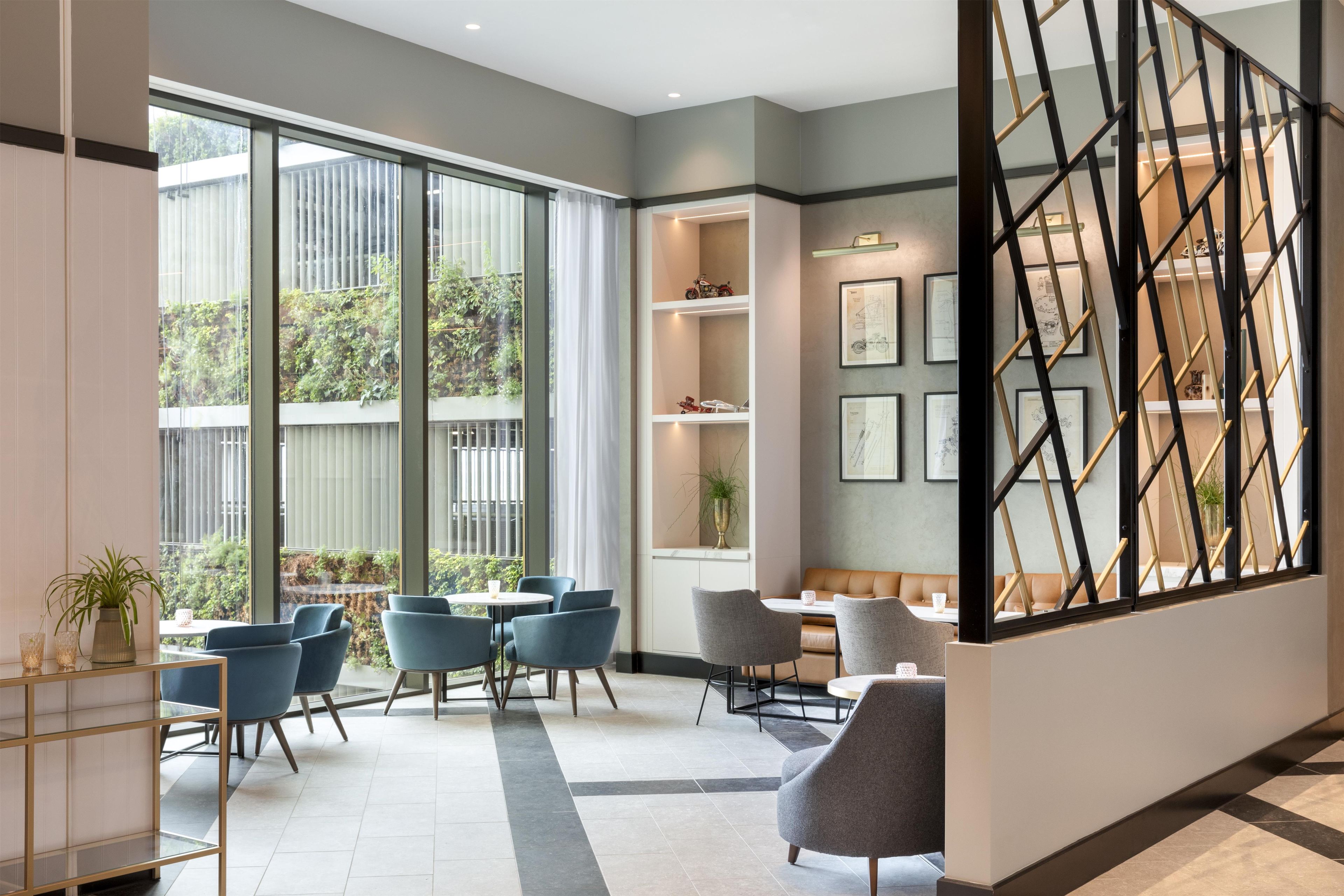 A modern interior with a seating area, large windows, and a staircase.