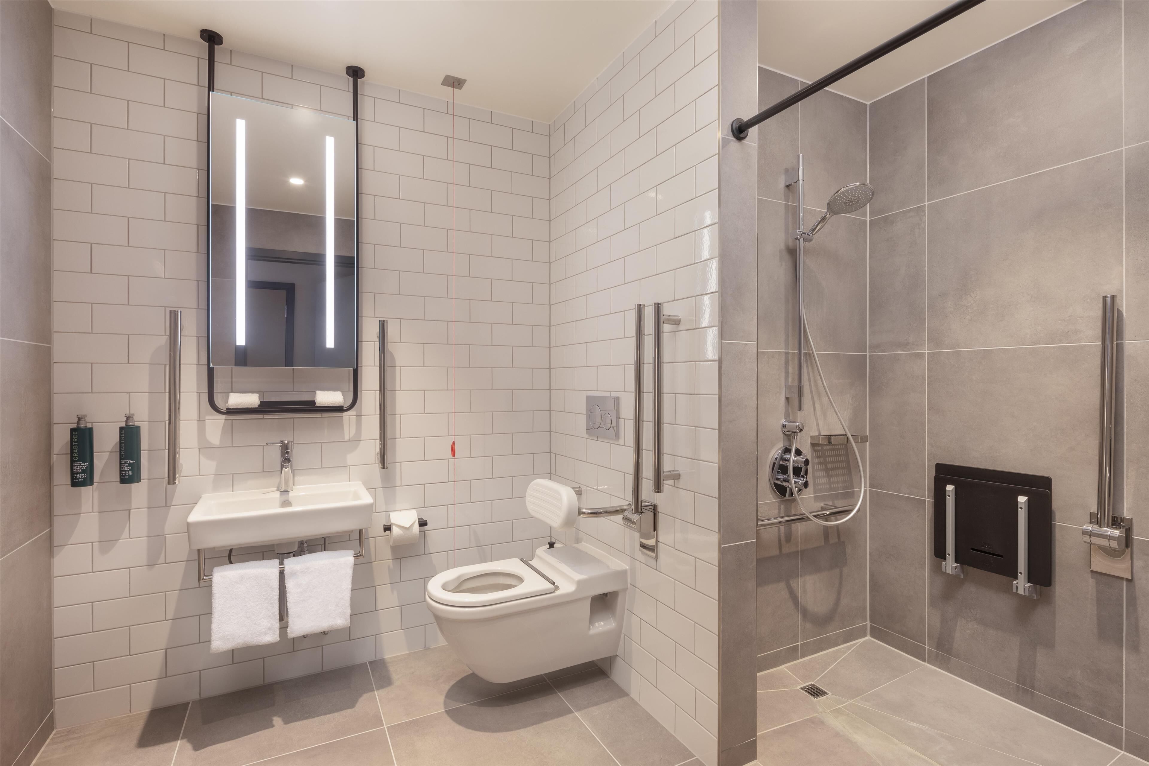 Une salle de bain moderne équipée de toilettes, d’un lavabo et d’une douche.