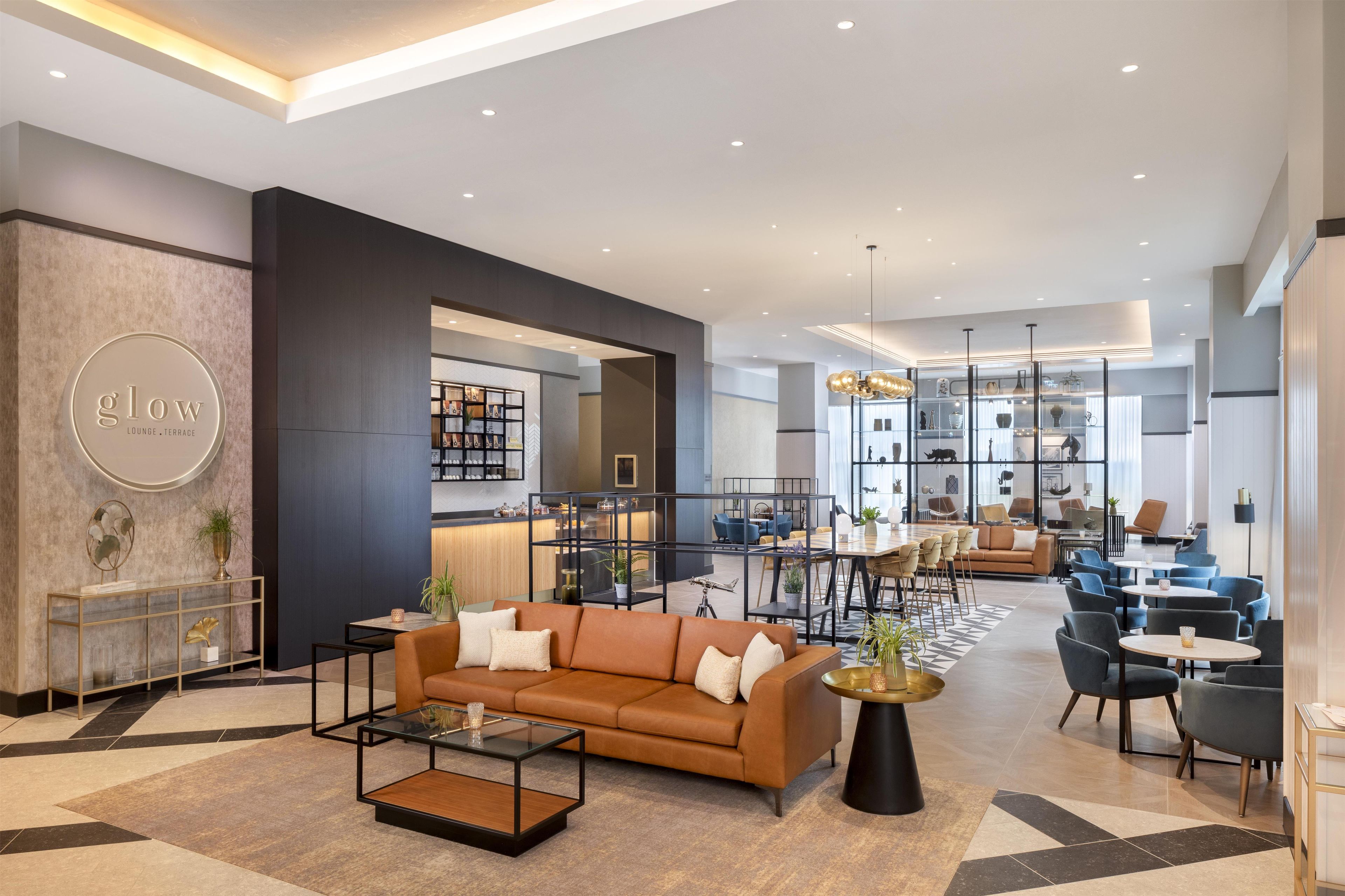 A modern lounge area with a sofa, coffee table, and a glass partition.