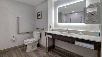 A modern bathroom with a toilet, sink, and mirror.