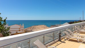 A balcony with sun loungers overlooking the sea. - The Nest - Stunning sea views, communal pool & walking distance to beach (Carvoeiro)