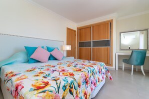 A bedroom with a bed, a desk, and a wardrobe.