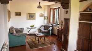 Ein gemütliches Wohnzimmer mit zwei gemusterten Sesseln, einem kleinen Tisch und einer Heizung.