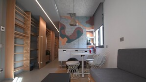 A modern interior with a dining area, a sofa, and a kitchen.