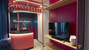 A modern bar area with a neon sign, a TV, and a seating area. - Tropicana Club: No conventional! (Rimini)