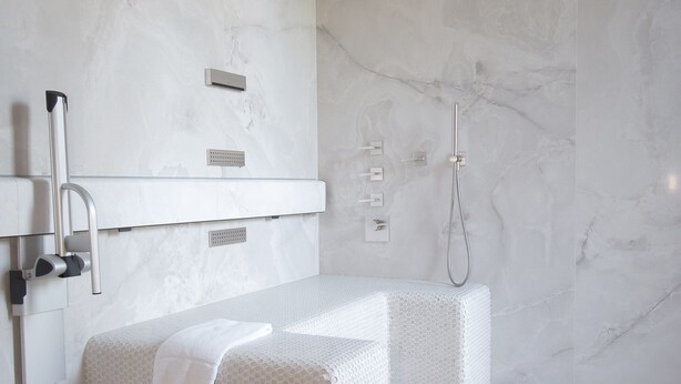 A modern bathroom with a large bathtub, a separate shower area, and a built-in vanity with a mirror. - In A Light Wave: Il mare, l’acqua. Flexibility and inclusiveness (Rimini)