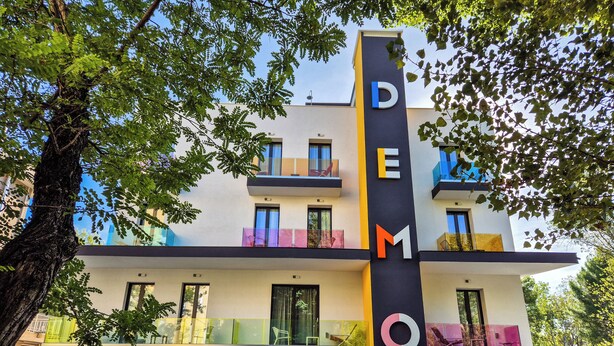 Un edificio moderno con un letrero vertical que dice "DEMO".