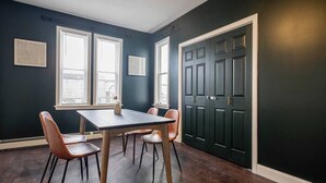 A dining area with a dark blue wall, a wooden table, and four chairs. - ★ Modern Renovation ★ 10-Bedrooms! Perfect For Large Groups! (Providence)