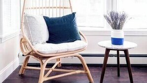 A wicker chair with cushions, a small round table with a vase, and a dark wooden floor. - ★ Modern Renovation ★ 10-Bedrooms! Perfect For Large Groups! (Providence)