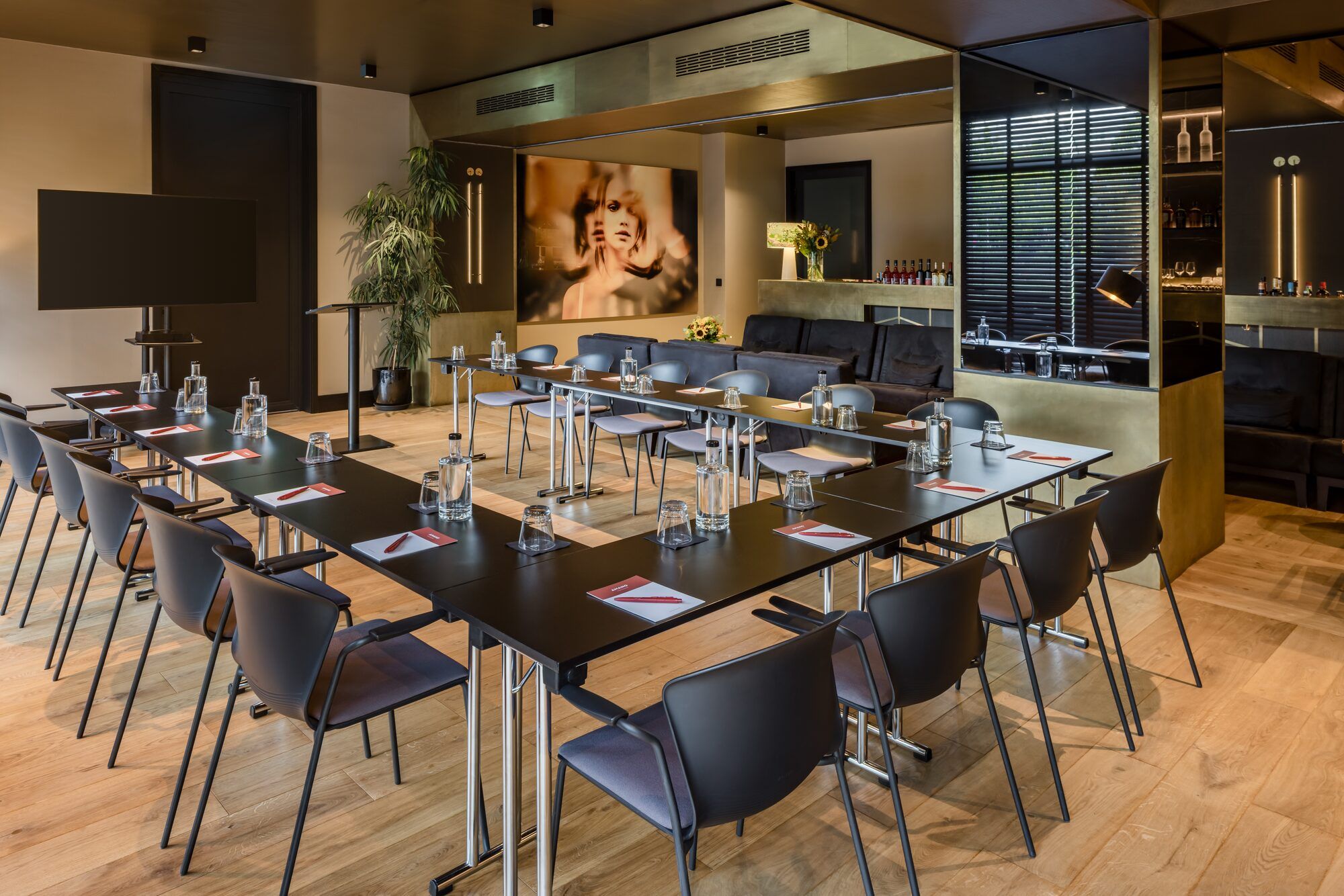 A conference room with a long table, chairs, and a bar area with shelves.