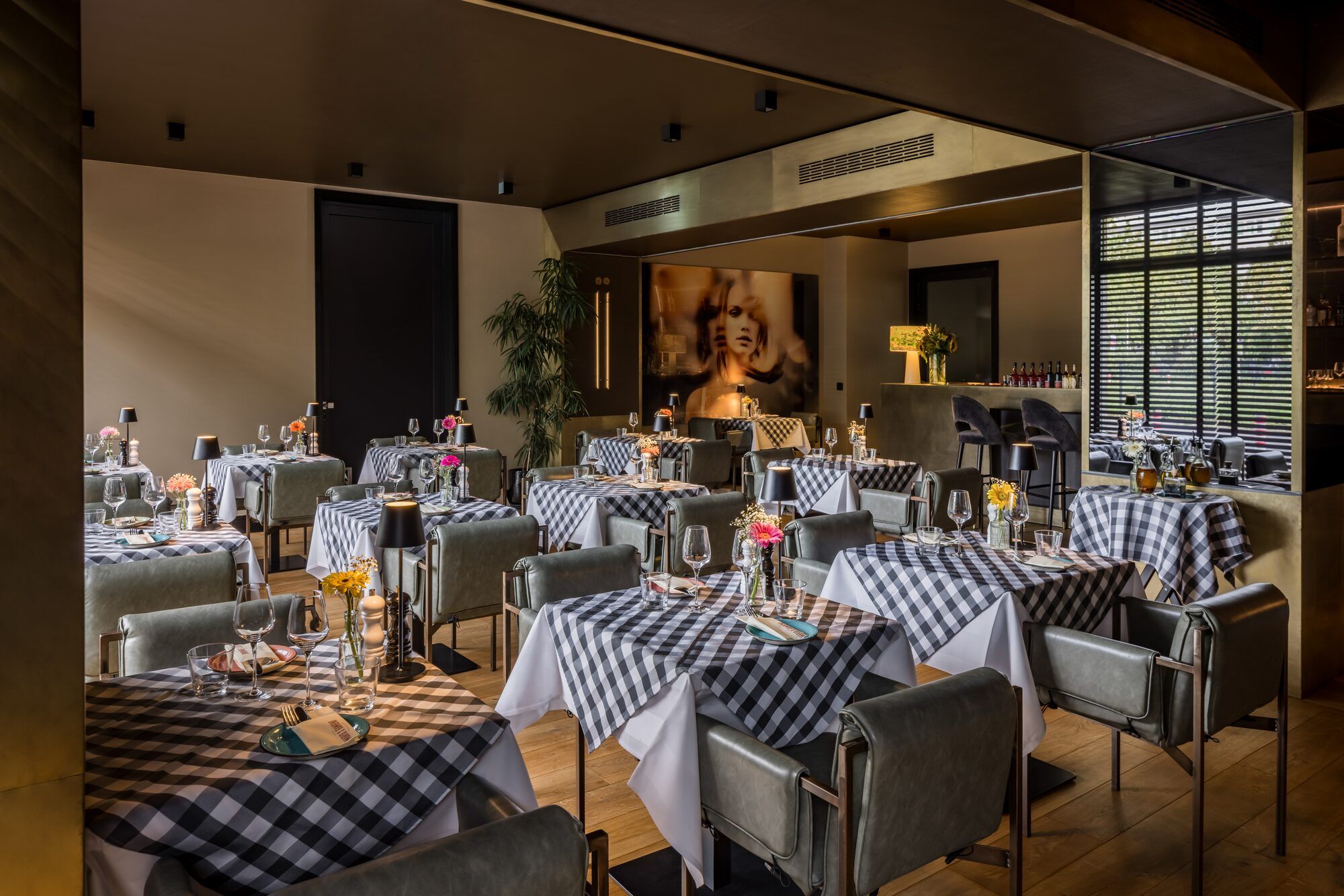 Un restaurant doté de nombreuses tables, chacune étant agrémentée de chaises, de verres et de couverts.