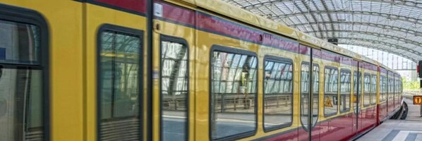 Un tren en una estación con andén techado.