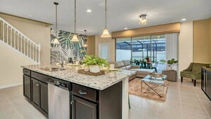 A spacious kitchen with a central island, dark cabinetry, and pendant lighting. - Themed rooms - Resort acess (Kissimmee)