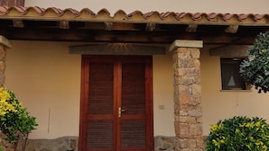 Um edifício com fachada de pedra, porta de madeira e telhado de telhas.