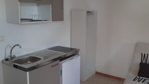 A compact kitchenette with a sink, a small refrigerator, and a microwave. - Charming, fully-equipped studio with mountain and sea views, 5 minutes from the beach (Schoelcher)