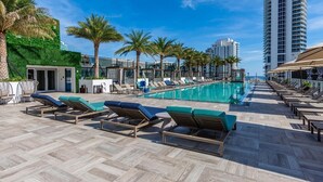 A rooftop pool area with lounge chairs, a swimming pool, and palm trees. - Enjoy the perfect blend of comfort, elegance, and luxury in this stunning 3-bedroom apartment (Hollywood)