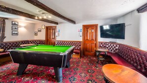 A billiards room with a pool table, leather seating, a television, and a patterned carpet. - George and Dragon Dent (Sedbergh)