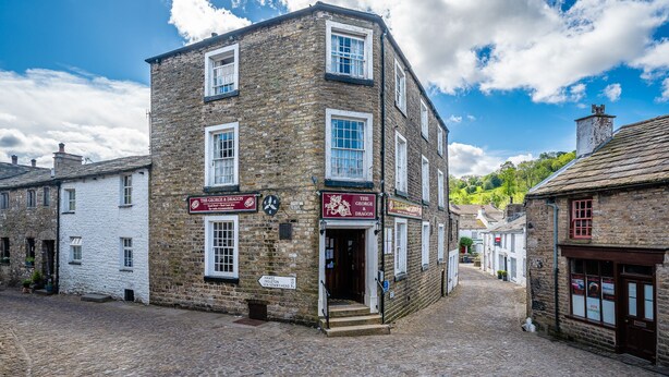 A two-story stone building with a sign for 'The George & Dragon' pub. - George and Dragon Dent (Sedbergh)